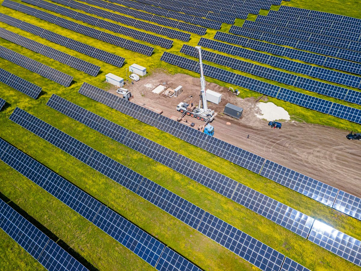 Solar plant under construction with crane and rows of panels