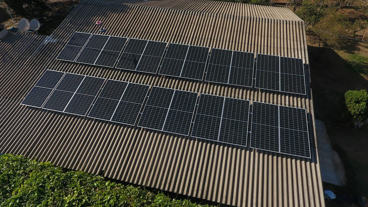 Aerial view of solar panels being installed on a large roof