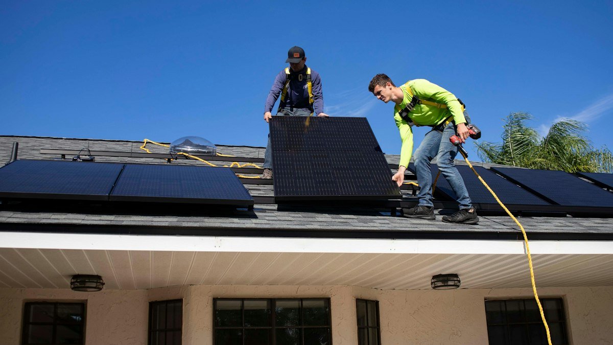 Installers mounting solar panels on a residential rooftop